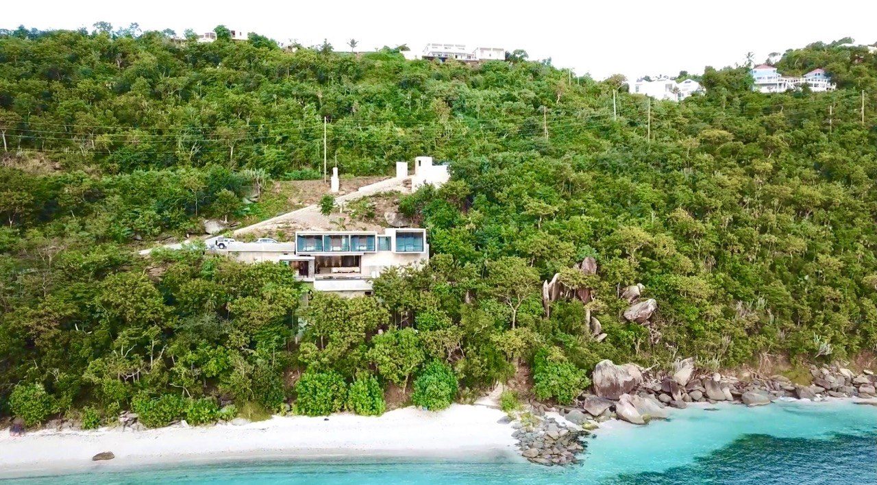 Aerial view of the residence above a white sand beach